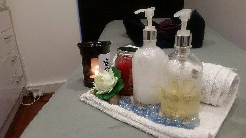 Treatment-table detail from a second angle: candle, lotus and twin oil pumps